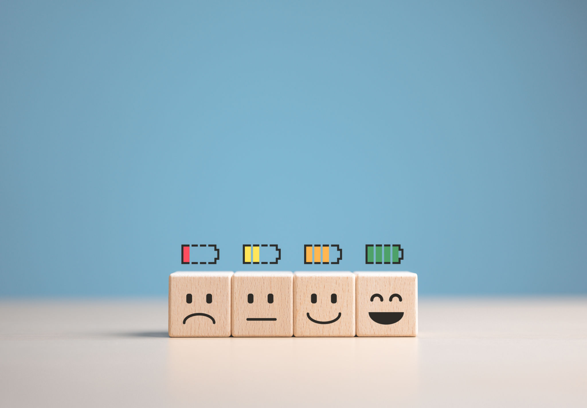 Percent of battery level from sadness to smiley face on wooden cube. Energy to motivate life, Emotional happiness level, World mental health day. Satisfaction, Burnout state, and Positive Thinking. Percent of battery level from sadness to smiley face on wooden cube. Energy to motivate life, Emotional happiness level, World mental health day. Satisfaction, Burnout state, and Positive Thinking.