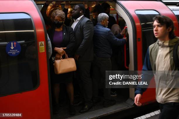 Commuters board a Piccadilly Line underground train in Stratford, east London, on October 4, 2023. Workers on the London Underground suspended their...