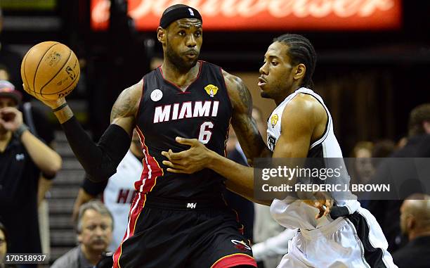 LeBron James of the Miami Heat looks to pass under pressure from Kawhi Leonard of the San Antonio Spurs during game four of the NBA finals on June...