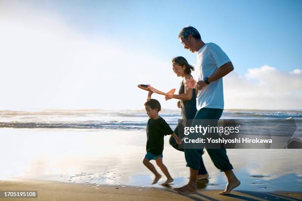 toddler running on beach with toy airplane - 家族　日本人　走る ストックフォトと画像