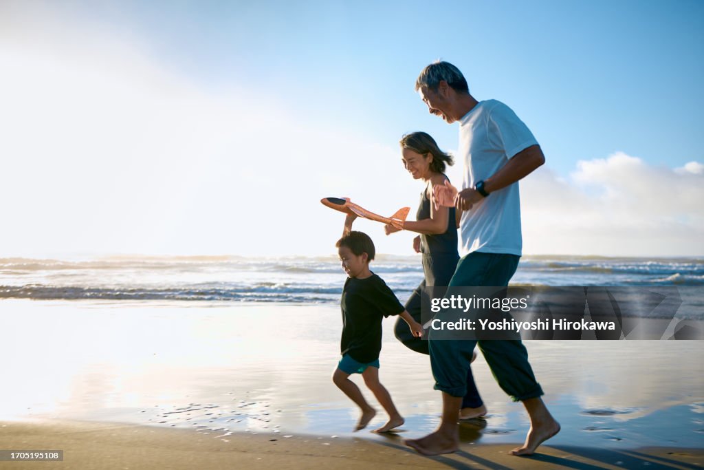Toddler running on beach with toy airplane