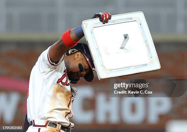 Ronald Acuna Jr. #13 of the Atlanta Braves raises second base after stealing it against Dansby Swanson of the Chicago Cubs in the 10th inning at...