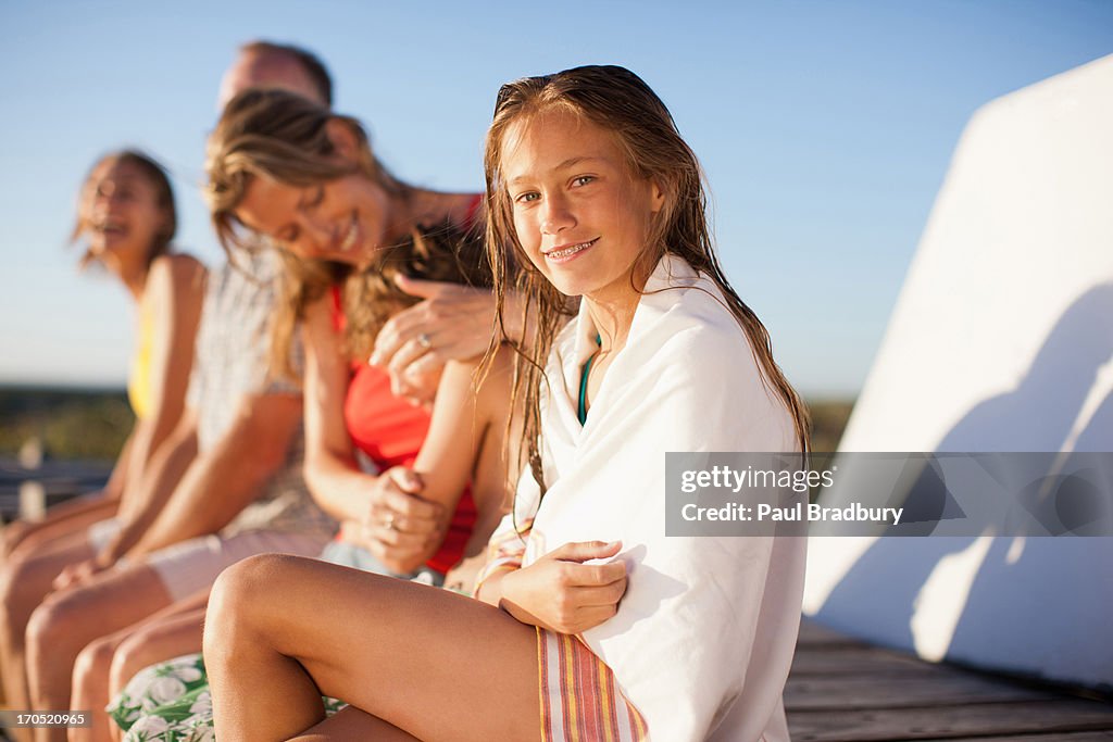Family sitting on pier near beach