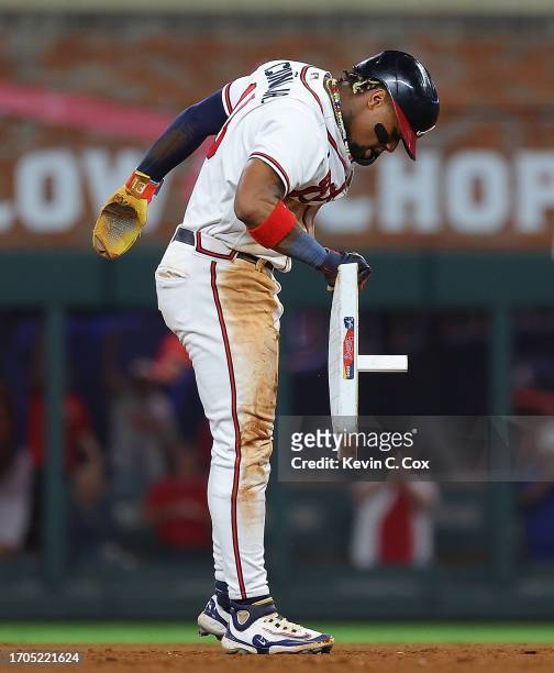 Ronald Acuna Jr. #13 of the Atlanta Braves removes second base after stealing it against Dansby Swanson of the Chicago Cubs in the 10th inning at...
