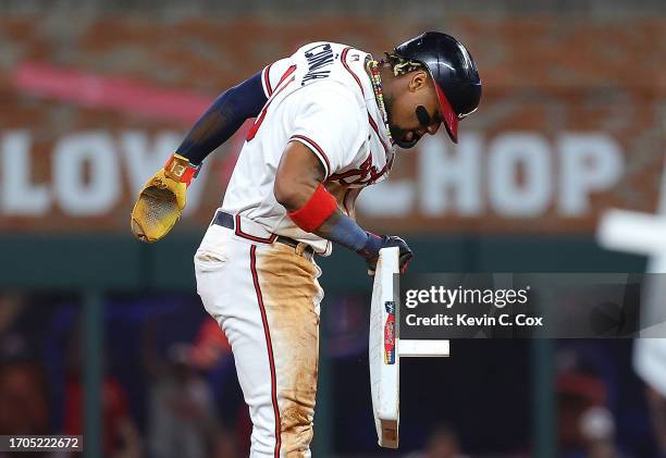 Ronald Acuna Jr. #13 of the Atlanta Braves removes second base after stealing it against Dansby Swanson of the Chicago Cubs in the 10th inning at...