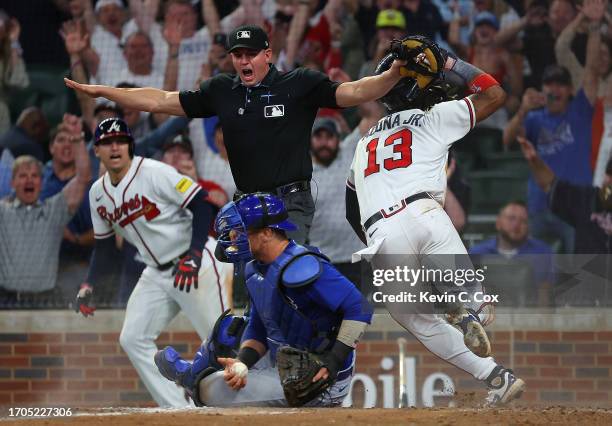 Ronald Acuna Jr. #13 of the Atlanta Braves slides safely against Yan Gomes of the Chicago Cubs as he scores the game-winning run on a walk-off single...
