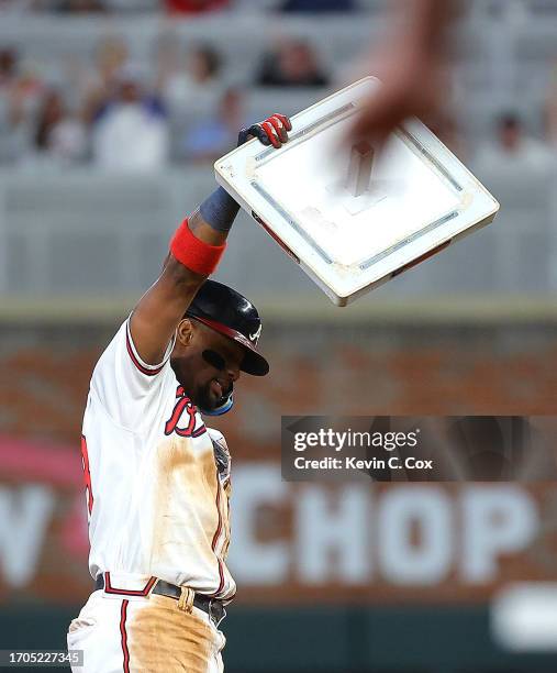 Ronald Acuna Jr. #13 of the Atlanta Braves raises second base after stealing it against Dansby Swanson of the Chicago Cubs in the 10th inning at...