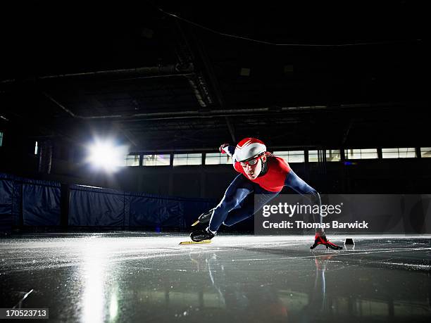 short track speed skater making turn during race - schaatsen stockfoto's en -beelden