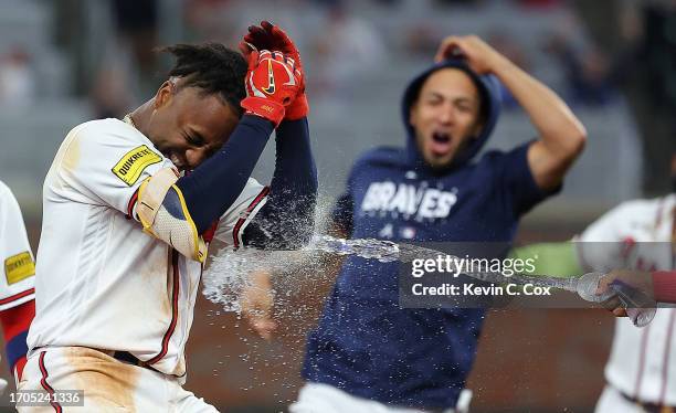 Ozzie Albies of the Atlanta Braves celebrates with teammates after hitting a walk-off single to give the Braves a 6-5 win over the Chicago Cubs in...