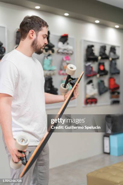 worker checking a skateboard from the skate store - skateboard shop stock pictures, royalty-free photos & images