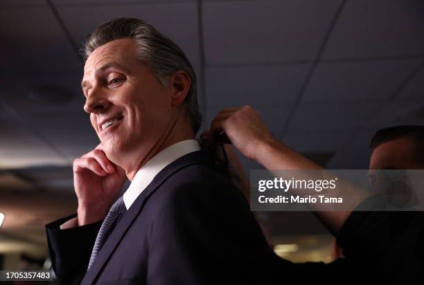 California Gov. Gavin Newsom talks to reporters in the spin room following the FOX Business Republican Primary Debate at the Ronald Reagan...