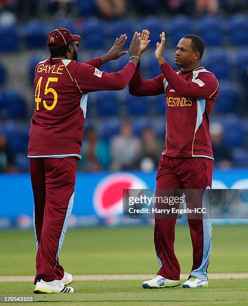 Marlon Samuels of the West Indies celebrates with team-mate Chris Gayle after dismissing Hashim Amla of South Africa during the ICC Champions Trophy...