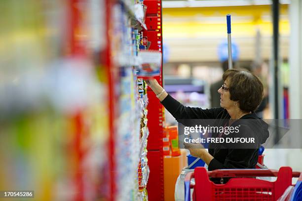 Customer looks at goods in a rack of a Carrefour supermarket, on June 14, 2013 in Sainte-Geneviève-des-Bois, outside Paris. Installed in...