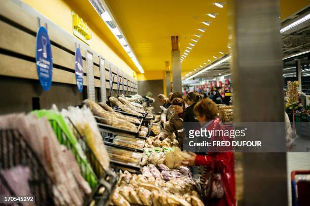 Customers look at breads at the bakery section of a Carrefour supermarket, on June 14, 2013 in Sainte-Geneviève-des-Bois, outside Paris. Installed in...