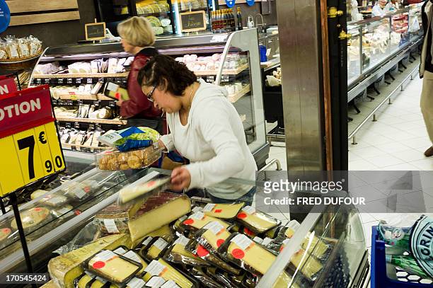 Customer look at cheeses in a Carrefour supermarket, on June 14, 2013 in Sainte-Geneviève-des-Bois, outside Paris. Installed in...
