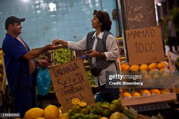 Woman pays for purchases at a market in Rio de Janeiro, Brazil, on Thursday, June 13, 2013. Brazilian retail sales rose in April at less than half...