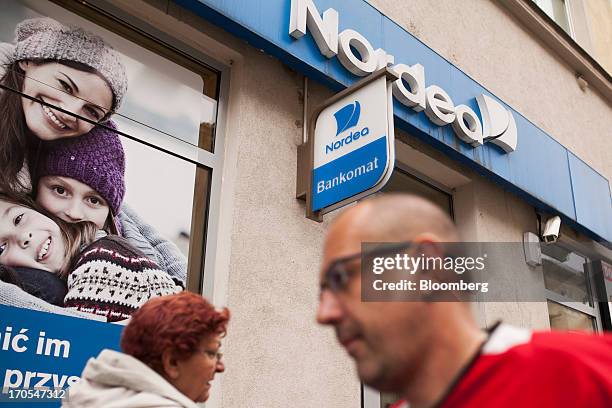 Pedestrians pass a sign outside a Nordea Bank Polska SA bank branch in Wroclaw, Poland, on Friday, June 14, 2013. PKO Bank Polski SA, Poland's...