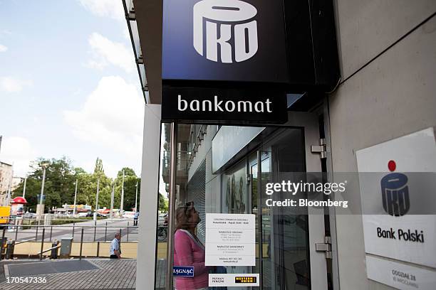 Customer enters a PKO Bank Polski SA bank branch in Wroclaw, Poland, on Friday, June 14, 2013. PKO Bank Polski SA, Poland's biggest lender, surged to...