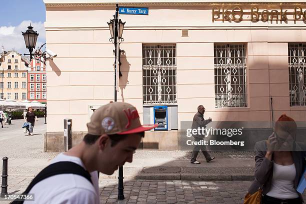 Pedestrians pass a PKO Bank Polski SA bank branch in Wroclaw, Poland, on Friday, June 14, 2013. PKO Bank Polski SA, Poland's biggest lender, surged...