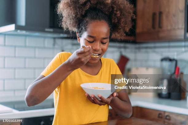happy girl having breakfast at home. - breakfast cereal stock pictures, royalty-free photos & images