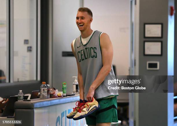 Boston, MA Boston Celtics PF Sam Hauser laughs as he carries his shoes.