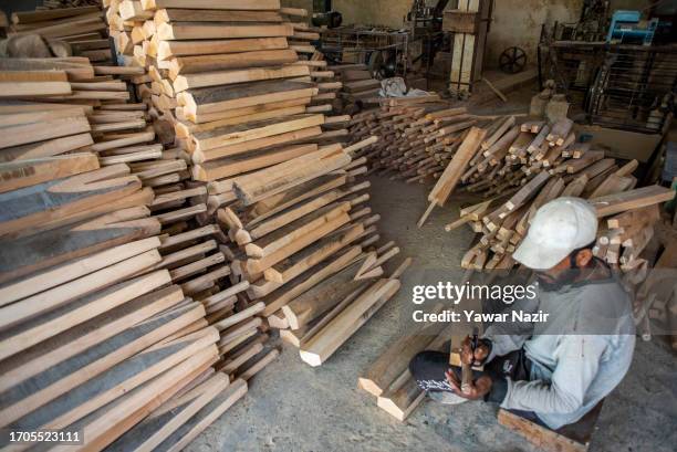 Worker gives numbering to unfinished bats in a bat factory on October 3, 2023 in Halmullah, 50 km, south of Srinagar, Indian administered Kashmir,...