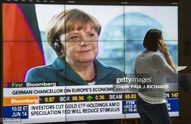 Unidentified woman on a cellphone walks in the lobby of the International Monetary Fund past a large TV screen, shortly before remarks by Christine...