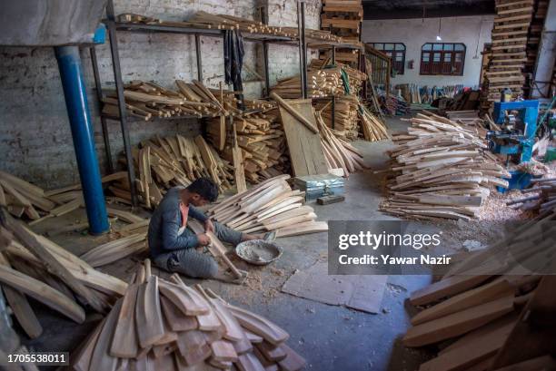 Skilled worker add the finishing touch to cricket bats in a bat factory on October 3, 2023 in Halmullah, 50 km, south of Srinagar, Indian...