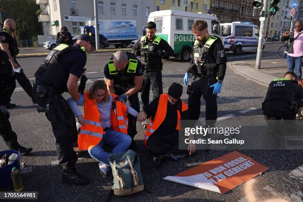 Police remove climate activists from the group "Last Generation" who were among seven who had glued themselves on the asphalt to block an...