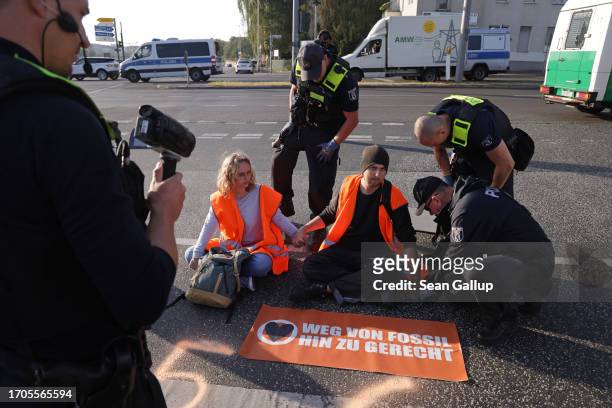 Police prepare to remove climate activists from the group "Last Generation" who were among seven who had glued themselves on the asphalt to block an...