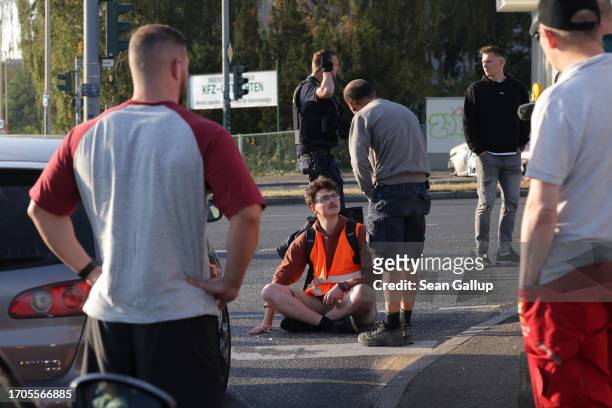 Motorist argues with an activist from the group "Last Generation" who was among seven who had glued themselves on the asphalt to block an...