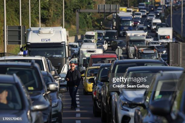 Motorists sit in a traffic jam on an offramp of the A100 highway blocked by activists from the group "Last Generation" who had glued themselves to...