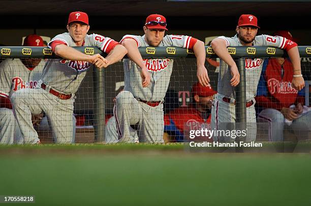 Chase Utley, Laynce Nix and Kevin Frandsen of the Philadelphia Phillies look on in the dugout during the game against the Minnesota Twins on June 11,...