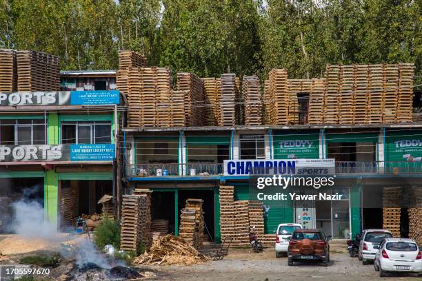 Willow cleft are left to dry on rooftops before turning them to cricket bats in a bat factory on October 3, 2023 in Halmullah, 50 km, south of...