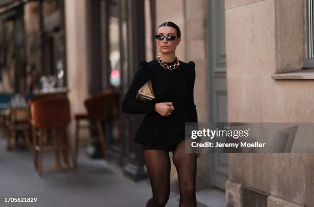 Carlotta Rubaltelli is seen outside The Row show wearing black thin sunnies, golden chain necklace, black padded shoulder top with matching short...