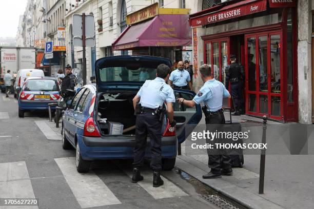 French gendarmes load, 27 June 2006 in Paris, a computor and a suitcasel seized during a search in a hotel and other shops in connection with an...