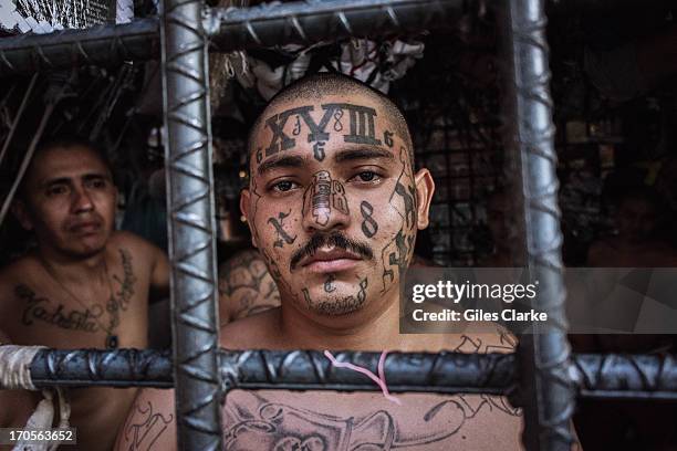 Gang members looks out through the bars of the designated M18 'gang cage' in the Quezaltepeque police station May 20, 2013 in San Salvador, El...