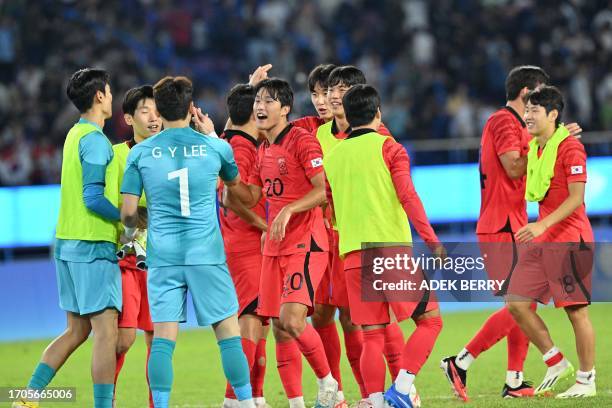 South Korea's team reacts after their win at the men's semi-final football match between South Korea and Uzbekistan at the 2022 Asian Games in...