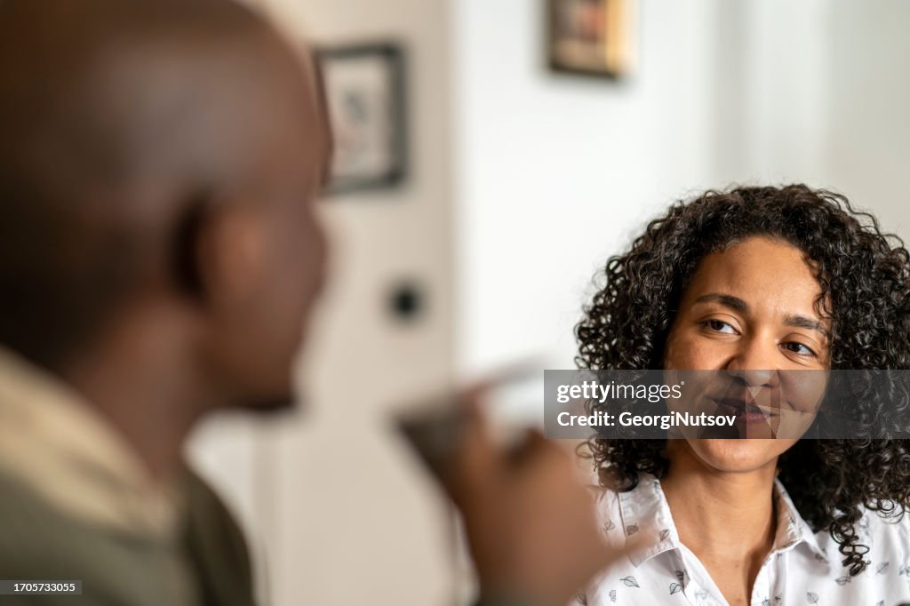 An African-American woman looks in disbelief at her husband.