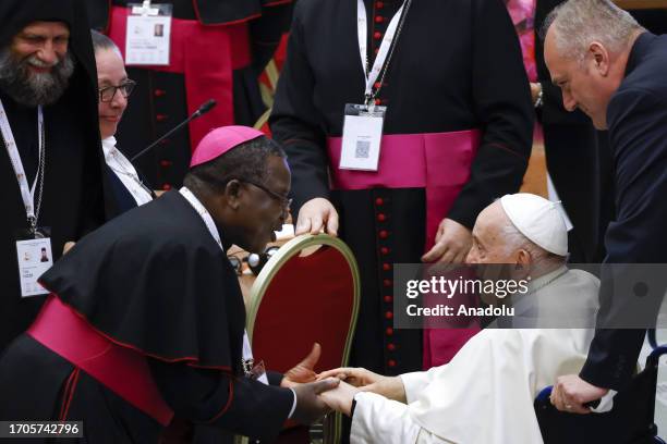 Pope Francis greets a bishop before the start of the XVI General Assembly of the Synod of Bishops in the Paul VI hall at the Vatican, on October 04,...