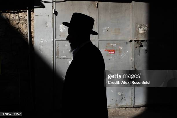 An Ultra-Orthodox Jewish man walks past a patch of light ahead of the holiday in the Ultra-Orthodox neighborhood of Mea Shearim on September 27, 2023...