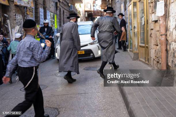 Ultra-Orthodox Jewish men run through a narrow street ahead of the holiday in the Ultra-Orthodox neighborhood of Mea Shearim on September 27, 2023 in...