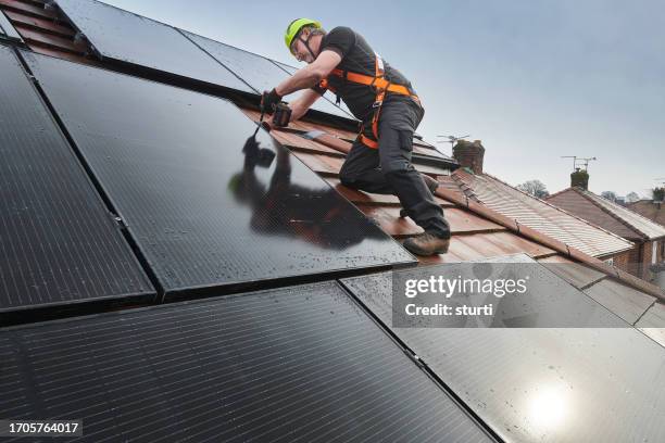 fitting the rooftop solar panels - safety harness stock pictures, royalty-free photos & images