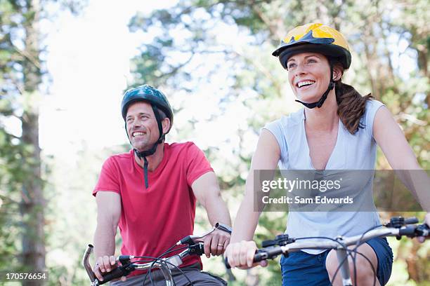 coppia biciclette equitazione nella foresta - casco bici foto e immagini stock