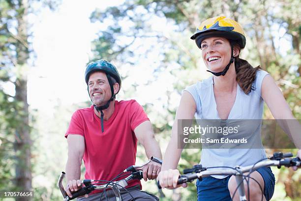 couple bicycle riding in forest - helmet stock pictures, royalty-free photos & images