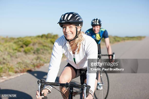 couple bicycle riding in remote area - sports helmet stock pictures, royalty-free photos & images