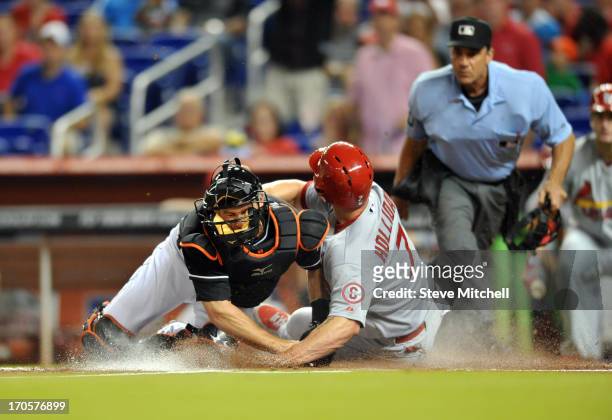 Matt Holliday of the St. Louis Cardinals slides home safety as Jeff Mathis of the Miami Marlins is late on the tag during the first inning at Marlins...