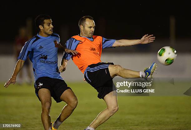 Spain's midfielder Andres Iniesta vies with forward Pedro Rodriguez during a training session at the Wilson Campos Training Centre near Recife,...