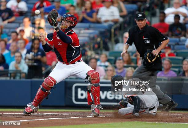 Third baseman Joaquin Arias of the San Francisco Giants slides into home plate before a throw to catcher Brian McCann of the Atlanta Braves while...