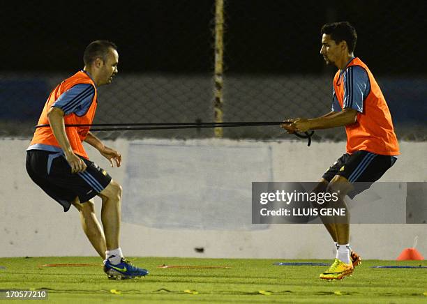 Spanish midfielder Andres Iniesta and midfielder Jesus Navas take part in a training session at the Wilson Campos Training Center near Recife,...
